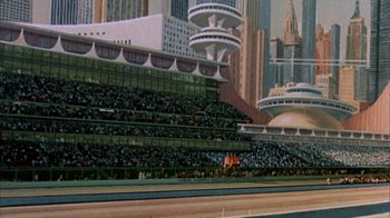Movie still from “Death Race 2000” (1975), directed by Paul Bartel – A painting of a crowd of people sitting in a stadium; Extreme Wide shot, High angle