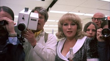 Movie still from “Death Race 2000” (1975), directed by Paul Bartel – A man and a woman standing next to each other; Close Up shot, Low angle