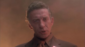 Movie still from “Death Race 2000” (1975), directed by Paul Bartel – A person wearing a suit and tie; Close Up shot, Low angle