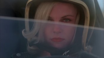 Movie still from “Death Race 2000” (1975), directed by Paul Bartel – A woman with blonde hair wearing a white hat; Close Up shot, Low angle