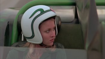 Movie still from “Death Race 2000” (1975), directed by Paul Bartel – A woman wearing a motorcycle helmet sitting in a car; Close Up shot, Low angle