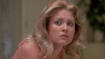 Movie still from “Death Race 2000” (1975), directed by Paul Bartel – A woman with long blonde hair looking at the camera; Close Up shot, Low angle