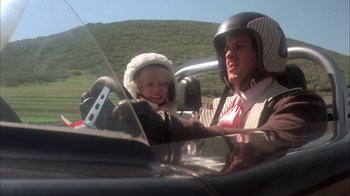 Movie still from “Death Race 2000” (1975), directed by Paul Bartel – A woman and a child in a car on a road; Close Up shot, Low angle