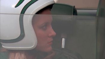 Movie still from “Death Race 2000” (1975), directed by Paul Bartel – A woman wearing a motorcycle helmet in a car; Close Up shot, Low angle