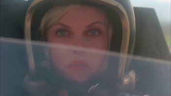 Movie still from “Death Race 2000” (1975), directed by Paul Bartel – A woman wearing a motorcycle helmet looking at the camera; Close Up shot, Overhead angle