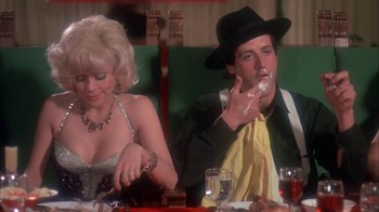 Movie still from “Death Race 2000” (1975), directed by Paul Bartel – A man and a woman sitting at a dinner table; Medium shot, Over the shoulder angle