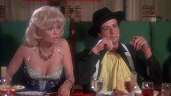 Movie still from “Death Race 2000” (1975), directed by Paul Bartel – A man and a woman sitting at a dinner table; Medium shot, Over the shoulder angle