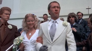 Movie still from “Death Race 2000” (1975), directed by Paul Bartel – A man and a woman dressed in a white suit; Close Up shot, Low angle