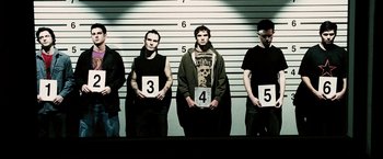 Movie still from “Death Sentence” (2007), directed by James Wan – A group of men standing next to each other in front of a police line - up; Medium shot, Low angle
