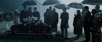Movie still from “Death Sentence” (2007), directed by James Wan – A group of people standing in the rain holding umbrellas; Wide shot, High angle