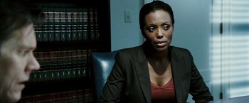 Movie still from “Death Sentence” (2007), directed by James Wan – A woman sitting in a chair in front of a book shelf; Close Up shot, Over the shoulder angle