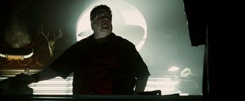 Movie still from “Death Sentence” (2007), directed by James Wan – A man standing in front of a table with a laptop on top of it; Medium shot, Low angle