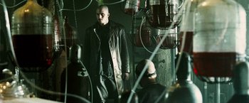 Movie still from “Death Sentence” (2007), directed by James Wan – A man in a leather jacket standing in a room; Medium shot, Low angle