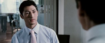 Movie still from “Death Sentence” (2007), directed by James Wan – A man wearing a shirt and tie in a room; Close Up shot, Over the shoulder angle