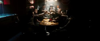 Movie still from “Death Sentence” (2007), directed by James Wan – A group of men sitting at a table drinking beer; Wide shot, Overhead angle