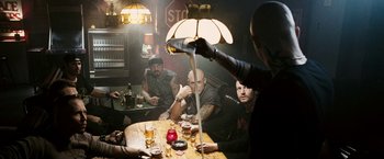 Movie still from “Death Sentence” (2007), directed by James Wan – A group of men sitting at a table drinking beer; Medium shot, Over the shoulder angle