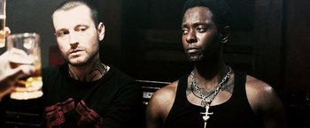 Movie still from “Death Sentence” (2007), directed by James Wan – A man with a cross on his neck and another man with a cross on his chest; Close Up shot, Low angle