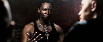 Movie still from “Death Sentence” (2007), directed by James Wan – A man wearing a black tank top and a chain necklace; Close Up shot, Over the shoulder angle