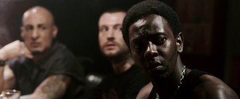 Movie still from “Death Sentence” (2007), directed by James Wan – Two men standing next to each other in a dark room; Close Up shot, Over the shoulder angle