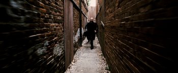 Movie still from “Death Sentence” (2007), directed by James Wan – A man walking down a narrow alley way; Wide shot, High angle