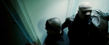 Movie still from “Death Sentence” (2007), directed by James Wan – A man with a bald head is standing next to a wall; Close Up shot, Over the shoulder angle