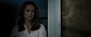 Movie still from “Death Sentence” (2007), directed by James Wan – A woman in a white shirt is standing in front of a window; Close Up shot, Over the shoulder angle