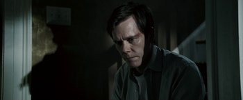 Movie still from “Death Sentence” (2007), directed by James Wan – A man in a dark room looking at the camera; Close Up shot, Over the shoulder angle