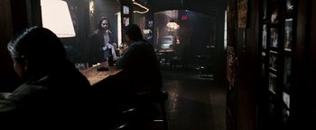 Movie still from “Death Sentence” (2007), directed by James Wan – A man sitting at a table in front of a mirror in a room; Wide shot, Over the shoulder angle