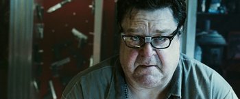 Movie still from “Death Sentence” (2007), directed by James Wan – An older man wearing glasses and a gray shirt; Close Up shot, Low angle