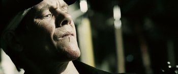 Movie still from “Death Sentence” (2007), directed by James Wan – A man's face with a scar on his face; Close Up shot, Low angle