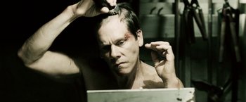 Movie still from “Death Sentence” (2007), directed by James Wan – A man is combing his hair in a mirror; Close Up shot, High angle