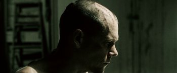 Movie still from “Death Sentence” (2007), directed by James Wan – A man with a shaved head looking to the side; Close Up shot, Low angle