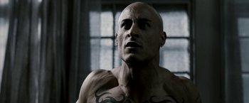 Movie still from “Death Sentence” (2007), directed by James Wan – A man with a tattoo on his chest looking upward; Close Up shot, Low angle