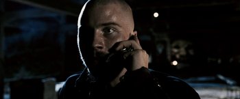 Movie still from “Death Sentence” (2007), directed by James Wan – A man with a bald head talking on a cell phone; Close Up shot, Low angle