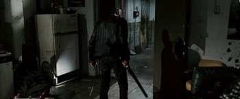 Movie still from “Death Sentence” (2007), directed by James Wan – A man holding a gun in a dark room; Wide shot, Over the shoulder angle
