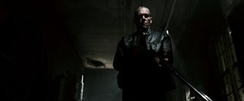 Movie still from “Death Sentence” (2007), directed by James Wan – A man wearing a leather jacket and holding a gun; Medium shot, Low angle