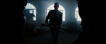 Movie still from “Death Sentence” (2007), directed by James Wan – A man holding a rifle in a dark room; Medium shot, Low angle