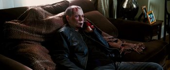 Movie still from “Death Sentence” (2007), directed by James Wan – A man with blood all over his face talking on a phone; Medium shot, High angle