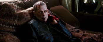 Movie still from “Death Sentence” (2007), directed by James Wan – A man with a bloody face sitting on a couch; Close Up shot, Over the shoulder angle
