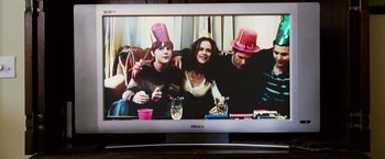 Movie still from “Death Sentence” (2007), directed by James Wan – Three people sitting in front of a television; Medium shot, Over the shoulder angle