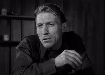 Movie still from “Decision Before Dawn” (1951), directed by Anatole Litvak – Black and white photograph of a man in a suit; Close Up shot, Low angle