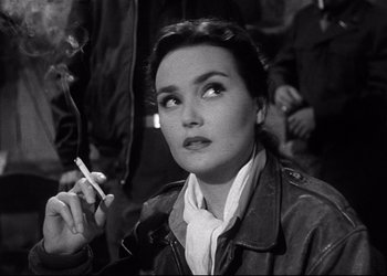 Movie still from “Decision Before Dawn” (1951), directed by Anatole Litvak – A black and white photo of a woman smoking a cigarette; Close Up shot, High angle