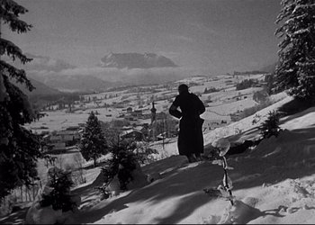 Movie still from “Decision Before Dawn” (1951), directed by Anatole Litvak – A man standing on top of a snow covered slope; Extreme Wide shot, Low angle