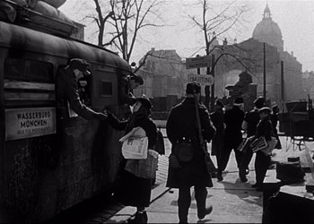 Movie still from “Decision Before Dawn” (1951), directed by Anatole Litvak – A group of people standing on the side of a train; Wide shot, Low angle