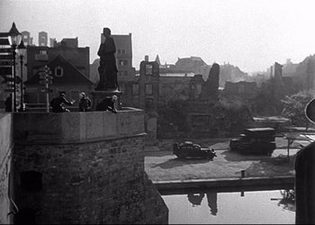 Movie still from “Decision Before Dawn” (1951), directed by Anatole Litvak – A black and white photo of a river and a city; Extreme Wide shot, High angle