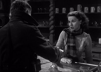 Movie still from “Decision Before Dawn” (1951), directed by Anatole Litvak – A man and a woman sitting at a table; Medium shot, Over the shoulder angle