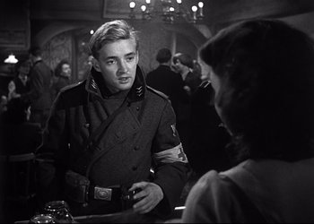 Movie still from “Decision Before Dawn” (1951), directed by Anatole Litvak – A man in a military uniform talking to a woman; Medium shot, Over the shoulder angle