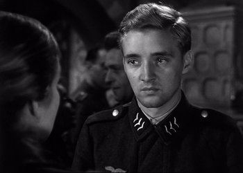 Movie still from “Decision Before Dawn” (1951), directed by Anatole Litvak – A young man in a military uniform looking at the camera; Close Up shot, Over the shoulder angle