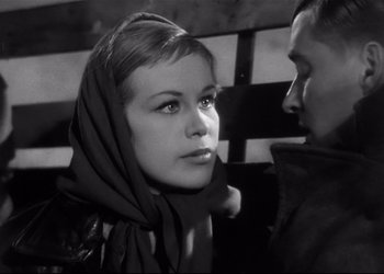 Movie still from “Decision Before Dawn” (1951), directed by Anatole Litvak – A woman with a scarf around her neck and a man with a scarf around her neck; Close Up shot, Low angle