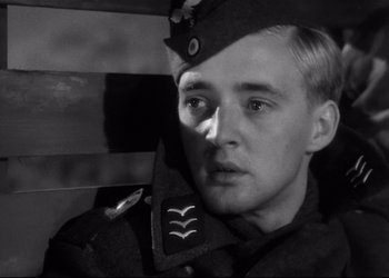 Movie still from “Decision Before Dawn” (1951), directed by Anatole Litvak – A man in a uniform looking at the camera; Close Up shot, Low angle